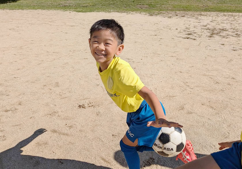 サッカースクールを笑顔で楽しむ子供たち